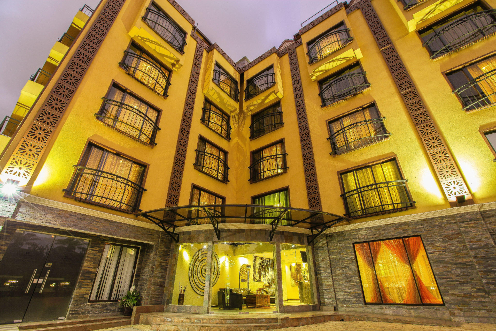 The illuminated courtyard exterior of The Monarch Hotel Nairobi